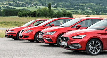 Las cuatro generaciones del SEAT León en color rojo aparcadas juntas mostrando su evolución de diseño